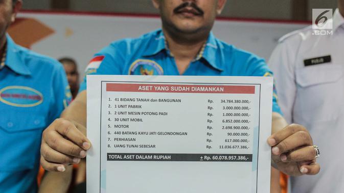 Petugas menunjukkan data aset yang sudah diamankan saat rilis kasus TPPU di Gedung BNN, Jakarta, Kamis (25/7/2019). BNN menyita total aset sebesar Rp 60 milliar. Aset tersebut berasal dari hasil ungkap 20 kasus narkotika dari Januari hingga Juli 2019. (Liputan6.com/Faizal Fanani)