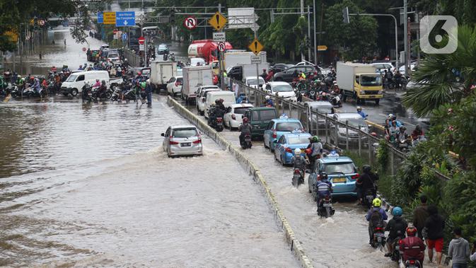 Sejumlah pengendara nekat menerobos genangan banjir di Jalan Gunung Sahari Jakarta, Selasa (25/2/2020). Hujan yang mengguyur Jakarta sejak Senin (24/2) malam membuat sejumlah kali meluap dan menyebabkan banjir. (Liputan6.com/Helmi Fithriansyah)
