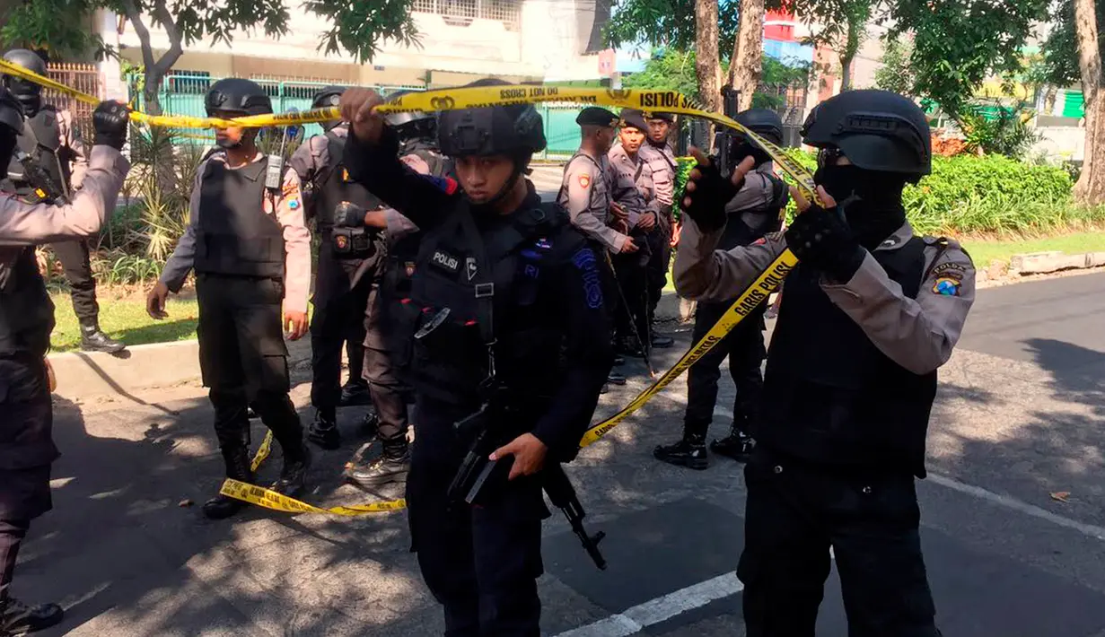 Petugas memasang garis polisi dekat lokasi ledakan bom di Gereja Santa Maria, Surabaya, Minggu (13/5). Polisi Selain di Gereja Katolik Santa Maria, dua ledakan lain di Gereja Pantekosta Pusat Surabaya dan Gereja Kristen Jawi Wetan. (AP/Trisnadi)