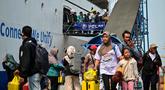 Para penumpang berjalan keluar untuk turun dari kapal di pelabuhan Perak, Surabaya, Jawa Timur pada Minggu 15 Maret 2026. Arus mudik di Pelabuhan Tanjung Perak, Surabaya, Jawa Timur, memasuki periode dengan jumlah penumpang yang signifikan. (JUNI KRISWANTO/AFP)