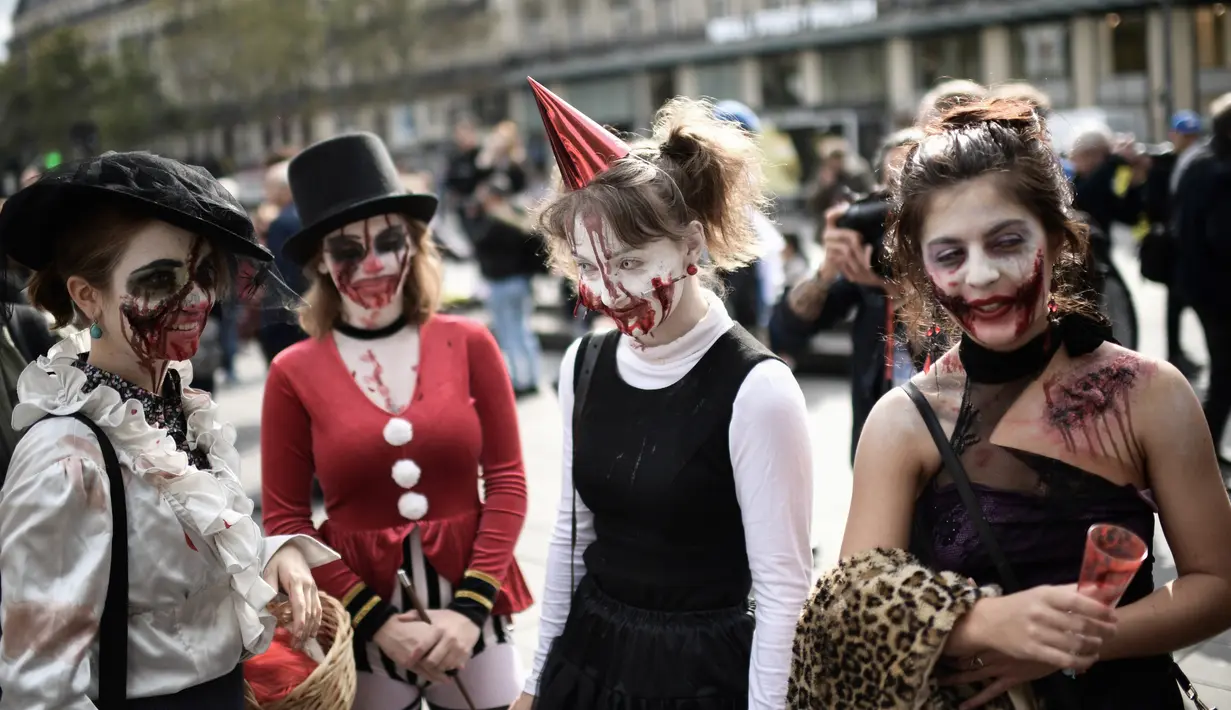 Penggemar film horor memakai kostum dan berdandan menyerupai zombie saat berpartisipasi dalam acara Zombie Walk di Place de la Republique, Paris, Sabtu (12/10/2019). Sejak 2008, acara Zombie Walk digelar untuk orang-orang yang terobsesi dengan mayat hidup. (Martin BUREAU / AFP)