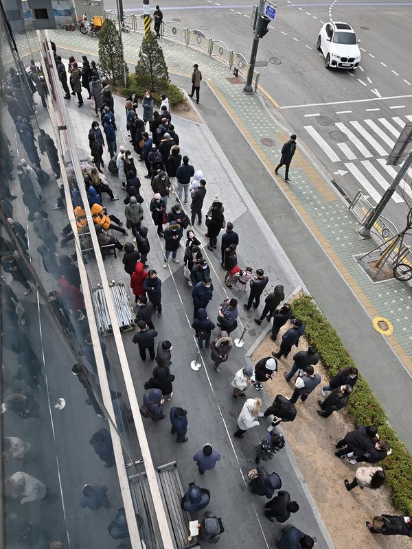 Warga mengantre untuk membeli masker di luar sebuah supermarket di Seoul, Korea Selatan, Rabu (4/3/2020). Infeksi virus corona atau COVID-19 di Korea Selatan hingga saat ini telah menewaskan 32 orang. (Jung Yeon-je/AFP)