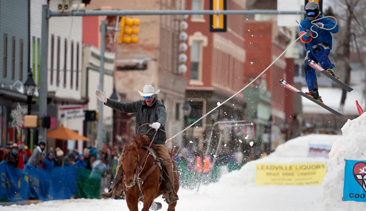 Joki kuda menarik pemain ski salju yang melompat saat mengikuti kompetisi Leadville Ski Joring ke-70 di Leadville, Colorado (4/3). Ski joring ini adalah olahraga yang berasal dari Skandinavia dan telah diadaptasi di Leadville. (AFP Photo/Jason Connolly)
