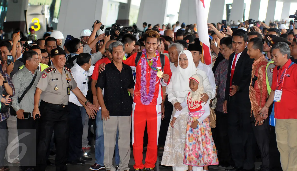 Ganda campuran Indonesia, Tontowi Ahmad bersama sang ayah memamerkan medali emas sesaa ttiba di Bandara Soekarno Hatta, Banten, Selasa (23/8/2016). Tontowi Ahmad/Lilyana Natsir berhasil meraih emas olimpiade Rio 2016. (Liputan6.com/HelmiFithriansyah)