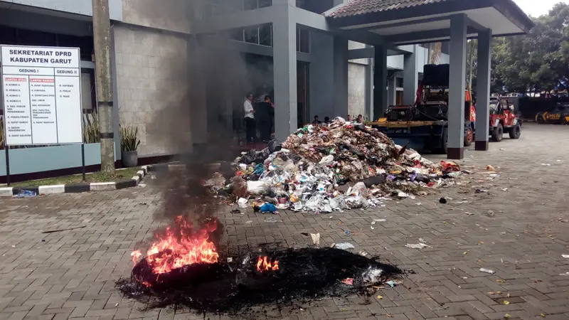 Ratusan massa KMB menghadiahi Gedung DPRD dengan sampah satu truk sampah