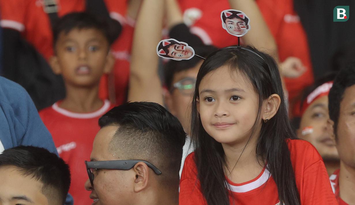 Suporter cilik tersenyum saat menyaksikan secara langsung pertandingan Timnas Indonesia vs Jepang pada laga Grup C putaran ketiga Kualifikasi Piala Dunia 2026 Zona Asia di Stadion Utama Gelora Bung Karno, Jakarta, Jumat (15/11/2024). (Bola.com.M Iqbal Ichsan)