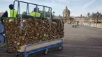Para pekerja memindahkan sebuah pagar besi yang dipenuhi gembok cinta di Jembatan Pont des Arts di atas Sungai Seine, Paris, Perancis, Senin (1/6/2015). (REUTERS/Philippe Wojazer)