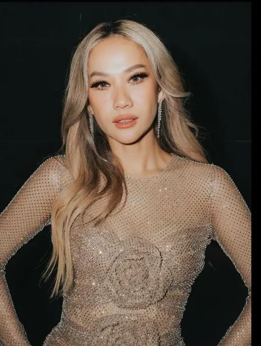 Rambut silvernya dibiarkan terurai dengan gaya belah duanya tanpa poni yang mengekspos keningnya. [@itsmebcl]