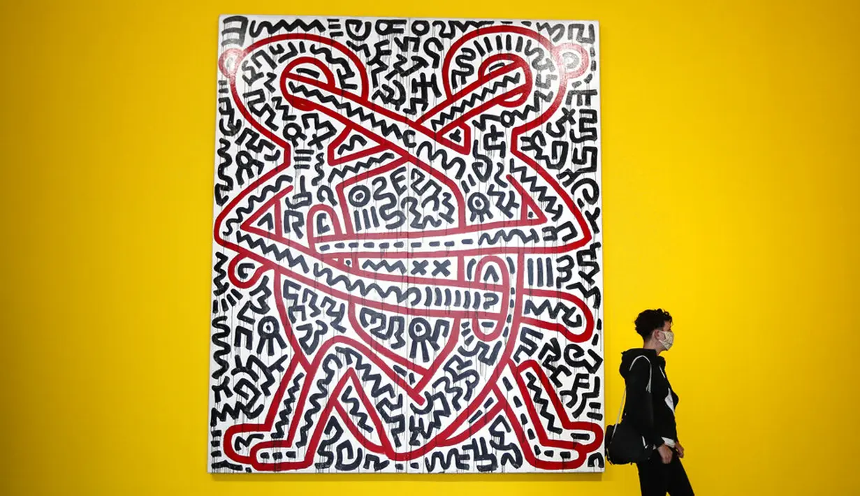 Pengunjung berjalan melewati karya seni seniman Amerika Serikat Keith Haring saat pameran di Museum Folkwang, Essen, Jerman, Selasa(1/9/2020). Keith Haring merupakan seniman jalanan asal New York yang meninggal akibat komplikasi AIDS pada tahun 1990. (AP Photo/Martin Meissner)