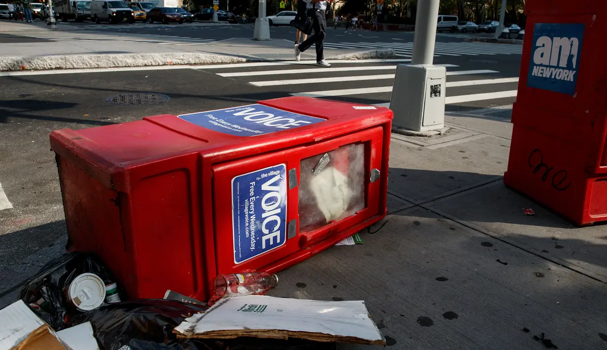 Sebuah kotak surat kabar Village Voice tergeletak di samping tempat sampah di Manhattan, AS (22/8). Village Voice  adalah surat kabar mingguan tertua dan paling terkenal di AS. (Drew Angerer/Getty Images/AFP)