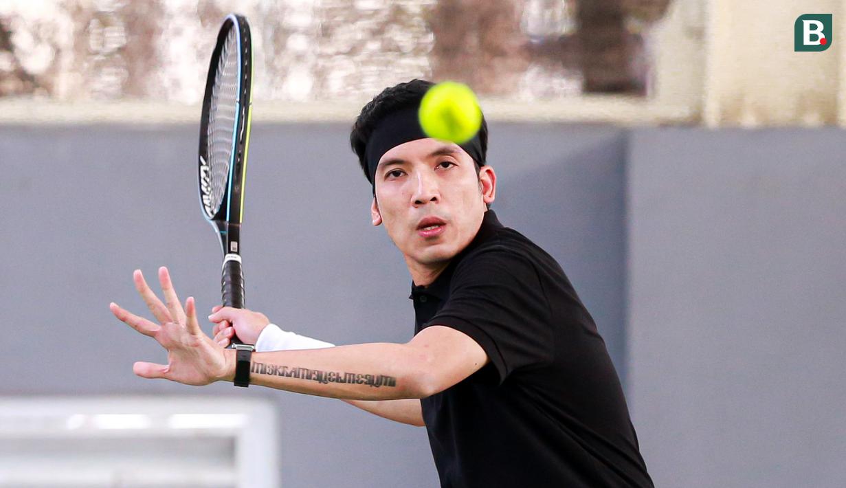 Selebritas Indonesia, Deddy Mahendra Desta berusaha mengembalikan bola ke arah pasangan Rezky Aditya dan Tanta Ginting pada laga tenis nomor ganda putra Turnamen Olahraga Selebriti Indonesia di GOR UNJ, Jakarta, Minggu (30/07/2023). Desta yang berpasangan dengan Raffi Ahmad menang dengan skor 4-6, 6-4, dan 6-4. (Bola.com/Bagaskara Lazuardi)