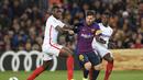 Aksi bintang Barcelona, Lionel Messi melewati dua pemain Sevilla pada leg kedua Copa Del Rey yang berlangsung di stadion Nou Camp, Barcelona, Kamis (31/1). Barcelona menang 6-1 atas Sevilla. (AFP/Luis Gene)