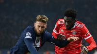 Bek PSG, Sergio Ramos (Kiri) berebut bola dengan gelandang Bayern Muenchen, Alphonso Davies selama pertandingan leg pertama babak 16 besar Liga Champions di stadion Parc des Princes di Paris, Rabu (15/2/2023). Bayern menang tipis atas PSG dengan skor 1-0. (AFP/Franck Fife)