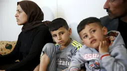 Murad dan adiknya Emad duduk bersama orang tuanya di rumahnya di kamp pengungsian dekat Kota Duhok, Irak, pada 19 April 2016. Sejumlah anak laki-laki Yazidi dipaksa mengikuti latihan untuk menjadi penerus militan ISIS. (REUTERS / Ahmed Jadallah)