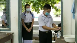 Para siswa yang mengenakan masker mengantre untuk mencuci tangan di sebuah sekolah di Vientiane, Laos, Selasa (19/5/2020). Siswa tingkat akhir sekolah dasar, menengah pertama, dan menengah di Laos sudah mulai bersekolah sejak 18 Mei 2020. (Xinhua/Kaikeo Saiyasane)
