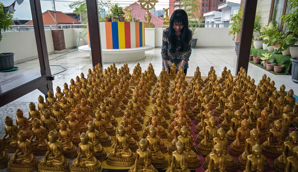 Tahun ini menandai dimulainya Tahun Kuda Api (Fire Horse), yang dalam astrologi Tiongkok melambangkan energi yang kuat, keberanian, dan perubahan yang cepat. Tampak dalam foto, seorang wanita menata patung-patung Buddha sebagai persiapan perayaan Tahun Baru Imlek 2577 Kongzili di Vihara Buddhayana, Surabaya, Jawa Timur pada Senin 9 Februari 2026. (JUNI KRISWANTO/AFP)