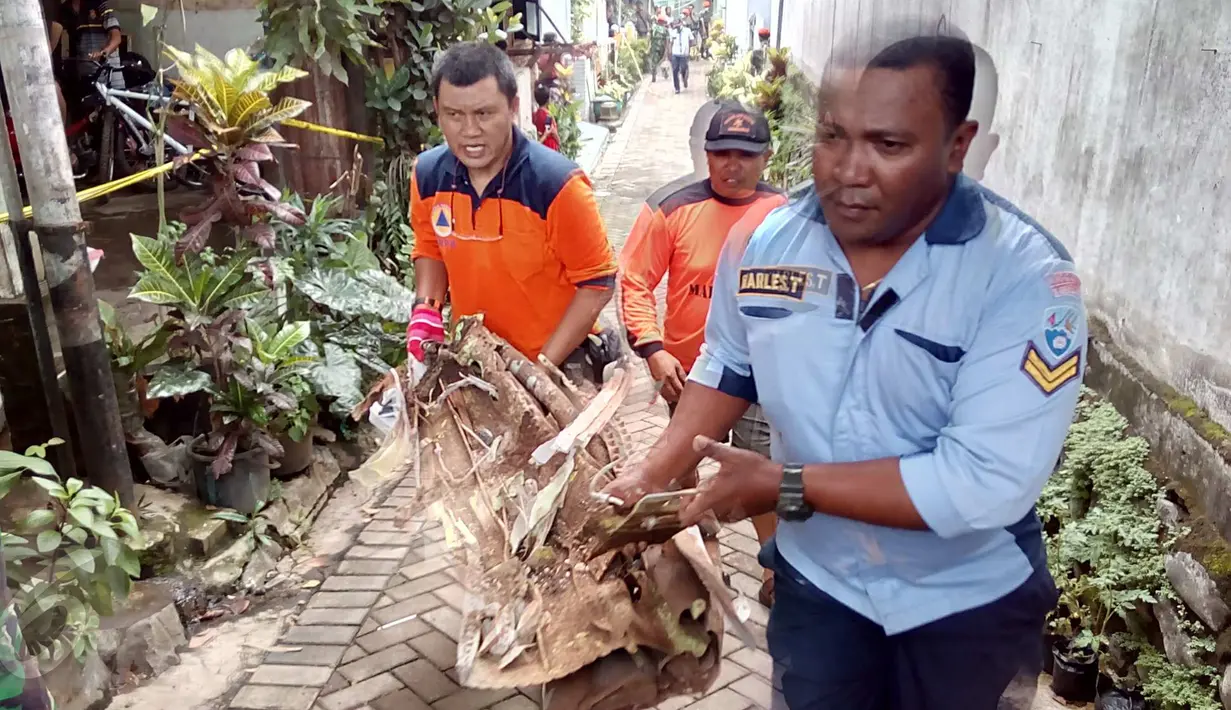 Petugas saat melakukan evakuasi serpihan pesawat Super Tucano yang jatuh menimpa rumah warga di kawasan Jalan LA Sucipto Kota Malang, Jawa Timur, (10/2). Pesawat diketahui berputar - putar di atas langit sebelum jatuh. (Liputan6.com/Zainul Arifin)