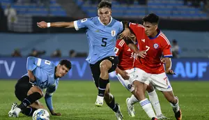 Gelandang Chile Marcelino Nunez, kanan, berbeut bola dengan gelandang Uruguay Manuel Ugarte  dalam Kualifikasi Piala Dunia 2026 zona CONMEBOL di Estadio Centenario, Sabtu (9/9/2023) pagi WIB. (AP Photo/Santiago Mazzarovich)