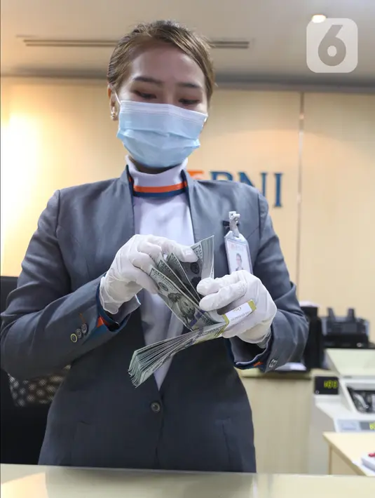 Karyawan bank menghitung uang dolar Amerika Serikat (AS) di Jakarta, Senin (2/11/2020). Nilai tukar rupiah pada perdagangan Senin (2/11) sore ditutup melemah 0,1 persen ke level Rp14.640 per dolar AS, dari perdagangan sebelumnya yaitu Rp14.690 per dolar AS. (Liputan6.com/Angga Yuniar)