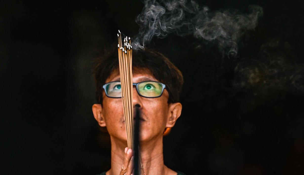 Suasana perayaan tahun ini diwarnai dengan rasa empati yang mendalam bagi para korban bencana alam yang melanda wilayah Aceh baru-baru ini. Tampak dalam foto, seorang pria membakar dupa saat berdoa di sebuah kuil pada hari pertama Tahun Baru Imlek 2577 Kongzili di Banda Aceh, Provinsi Aceh, pada Selasa 17 Februari 2026. (CHAIDEER MAHYUDDIN/AFP)