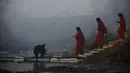 Wanita Hindu Nepal menyebrangi sungai Saali saat festival Swasthani Brata Katha di Kathmandu, Nepal, (24/1). Selama festival umat Hindu Nepal membaca kitab suci Hindu yang didedikasikan untuk dewi Swasthani dan Dewa Siwa. (REUTERS/Navesh Chitrakar)