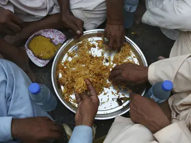 Warga berbuka puasa bersama selama bulan suci Ramadan di Karachi, Pakistan, Selasa (12/5/2020). Warga berbuka puasa bersama setelah pemerintah melonggarkan lockdown terkait pandemi virus corona COVID-19. (AP Photo/Fareed Khan)