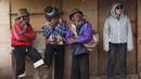Sejumlah pria Andean dan seorang wisatawan meneduh saat hujan di Gunung Pelangi di Pitumarca, Peru (5/4). Rainbow Mountain terdiri dari hamparan pasir berwarna-warni seperti pelangi. (AP Photo/Martin Mejia)
