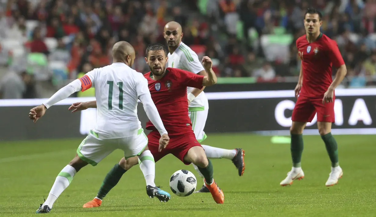 Striker Portugal, Bernardo Silva, berusaha melewati pemain Aljazair, Yacine Brahimi, pada laga uji coba di Estadio da Luz, Jumat (8/6/2018). Portugal menang 3-0 atas Aljazair. (AP/Armando Franca)