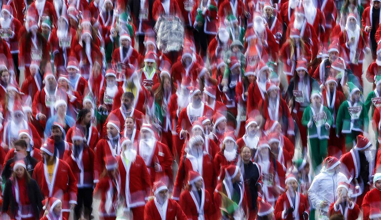 Ribuan orang yang mengenakan kostum Santa Claus berpartisipasi dalam edisi ke-14 lomba Santa Claus, sebuah lari santai sejauh 4,5 km melalui jalan-jalan Madrid pada Minggu 21 Desember 2025. Jelang perayaan Natal, sebuah gelaran lari amal melalui jalan-jalan utama kota Madrid, Spanyol digelar pada Minggu 21 Desember 2025. (OSCAR DEL POZO/AFP)