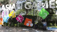 Pekerja memasang neon box Asian Games di depan Balai Kota DKI Jakarta, Jumat (6/7).Lampu neon box berwarna warni yang dipasang menggambarkan berbagai cabang olahraga yang akan dipertandingkan dalam Asian Games 2018. (Liputan6.com/Arya Manggala)