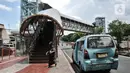 Sebuah angkutan umum berhenti di bawah jembatan penyeberangan orang (JPO) di Jalan Kolonel Sugiono, Duren Sawit, Jakarta, Senin (7/2/2022). Tak hanya menonjolkan keindahan arsitekturnya, JPO ini juga ramah bagi penyandang disabilitas karena sudah dilengkapi dengan lift. (merdeka.com/Iqbal S Nugroho)