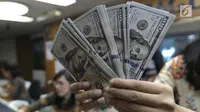 Teller menghitung mata uang dolar di penukaran uang di Jakarta, Jumat (20/4). Nilai tukar rupiah terhadap dolar AS pagi ini melemah ke posisi di Rp 13.820. (Liputan6.com/Angga Yuniar)