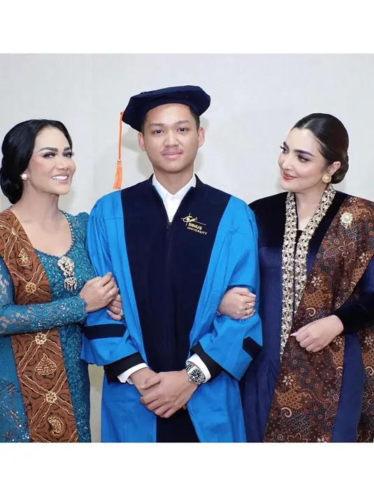 <p>Momen mengharukan terjadi di acara kelulusan Azriel Hermansyah. Di acara tersebut, Azriel didampingi oleh kedua ibunya, yaitu Ashanty dan Krisdayanti. Ashanty memesona dibalut kebaya biru tua dari bahan beludru. Kebaya panjangnya memiliki detail bordir emas di bagian kerahnya yang memanjang ke Bawah. Sedangkan Krisdayanti mengenakan kebaya berwarna biru kehijauan yang tak kalah menawan. Desain kebaya yang dikenakan oleh Krisdayanti lebih klasik dengan sentuhan bros emas di bagian tengah dada. [Foto: Instagram/ashanty_ash]</p>