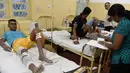 Korban dari bangunan yang roboh mendapat perawatan di Kolombo, Sri Lanka, Kamis (18/5). Sedikitnya 20 pekerja berhasil diselamatkan dan puluhan lainnya masih dalam tahap pencarian. (AFP/Ishara S. KODIKARA)