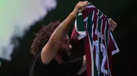 Marcelo menunjukkan baju dan nomor punggung yang akan ia gunakan saat perkenalan pemain baru Fluminense di Stadion Maracana, Rio de Janeiro, Brasil, Sabtu (11/03/2023) WIB. Mantan pemain Real Madrid tersebut bergabung hingga Desember 2024. (AFP/Carl De Souza)