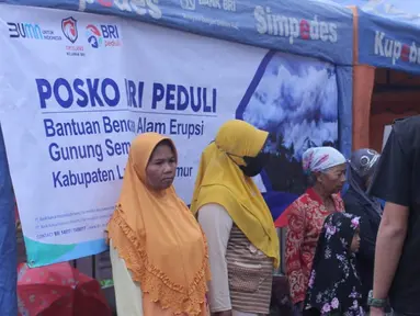 Warga terdampak erupsi Gunung Semeru menerima bantuan dari BRI melalui CSR BRI Peduli di posko BRI Peduli Bencana Semeru yang dibangun Insan BRILian dan pihak terkait di Jalan Raya Pasar Penanggal, Desa Penanggal,Kecamatan Candipuro, Kabupaten Lumajang, Senin (06/12/2021).(Liputan6.com/HO/Humas BRI)