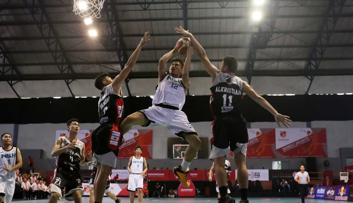 Pemain NSH Jakarta, Yoseph Wijaya melakukan Lay Up saat dihadang para pemain M88 Aspac Jakarta, pada laga IBl Reguler Season di Hall A Senayan, Jakarta, Minggu (10/1/2016). Aspac Jakarta menang 78-61. (Bola.com/Nicklas Hanoatubun)