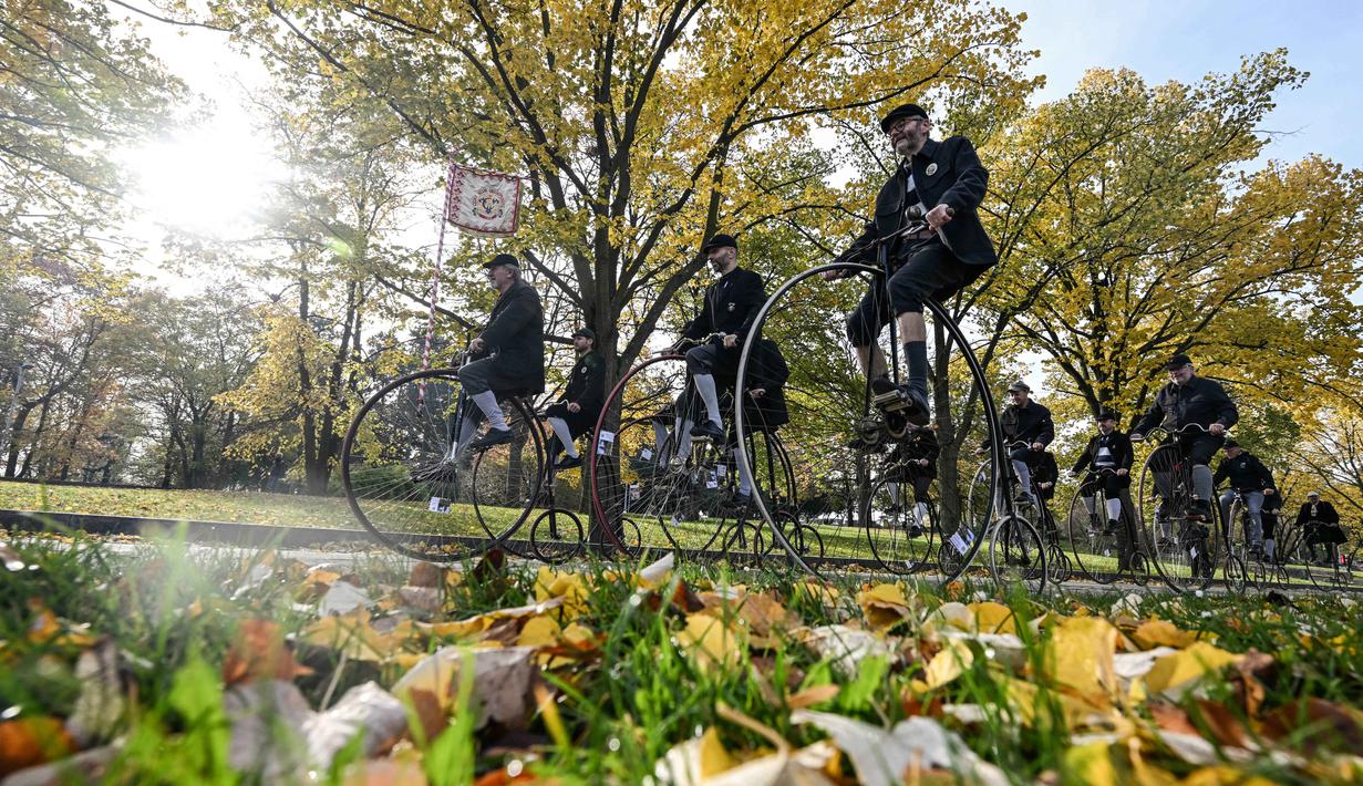 Para penggemar sepeda yang mengenakan pakaian bersejarah mengendarai sepeda yang mereka sebut penny-farthing, atau yang juga dikenal sebagai high wheel, dalam kompetisi tradisional 'One Mile Race' di Taman Letna, Praha, Republik Ceko, pada 1 November 2025. Mengenakan kostum bersejarah, penggemar sepeda model kuno yang disebut 'penny-farthings' berkumpul di Taman Letna, Praha, Republik Ceko, pada 1 November 2025. (Michal Cizek/AFP)