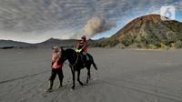 Pemilik kuda mengantarkan pengunjung berkuda di lautan pasir Gunung Bromo, Probolinggo, Jawa Timur, Jumat (10/9/2021). Balai Besar Taman Nasional Bromo Tengger Semeru (BB-TNBTS) mulai membuka pintu masuk kawasan wisata Bromo melalui Kabupaten Probolinggo. (merdeka.com/Arie Basuki)