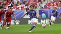 Striker Timnas Jepang, Ayase Ueda melakukan eksekusi penalti yang menghasilkan gol pertama ke gawang Indonesia pada laga ketiga Grup D Piala Asia 2024 di Al-Thumama Stadium, Doha, Qatar, Rabu (24/1/2024) malam WIB. (AFP/Giuseppe Cacace)