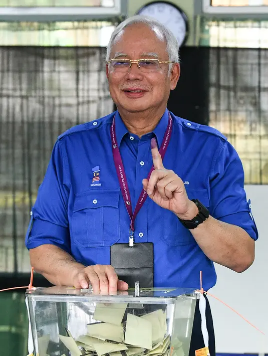Perdana Menteri Malaysia, Najib Razak menunjukan jari yang telah diberi tinta usai memberikan hak suaranya di Pekan, Pahang, Rabu (9/5). Pemilu ini pertarungan antara PM Najib yang sudah berkuasa sejak 2009, melawan Mahathir Mohamad. (MOHD RASFAN / AFP)