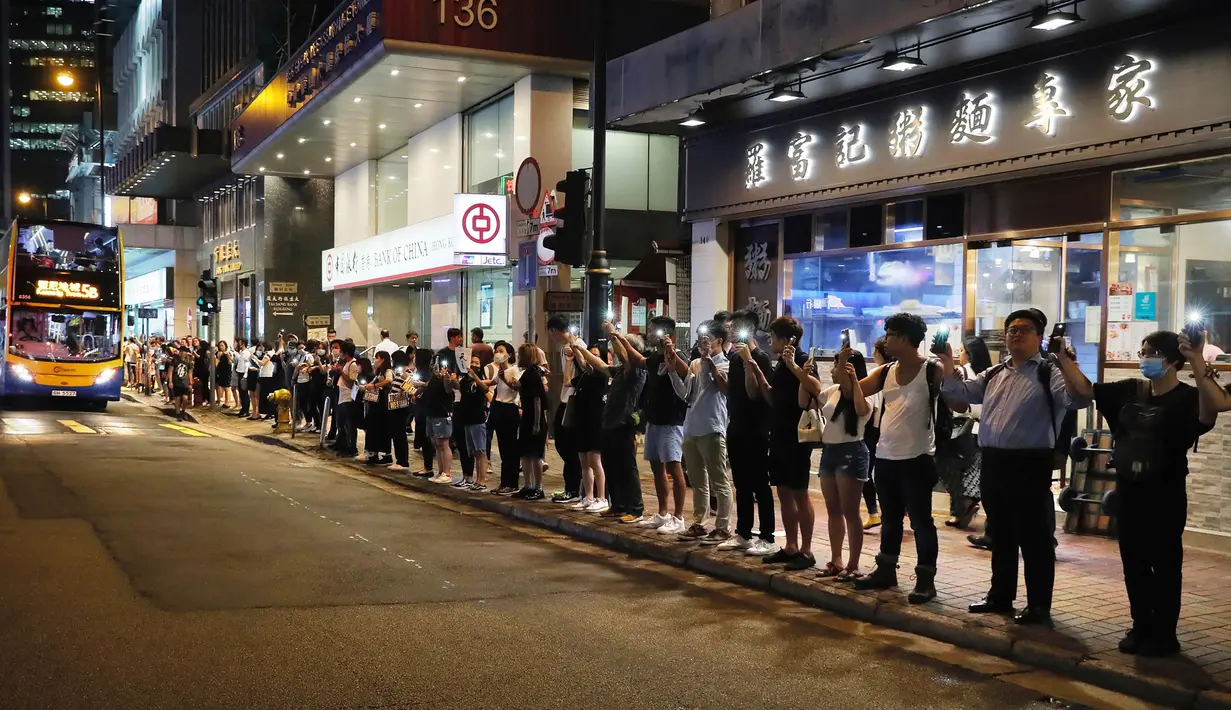 Demonstran prodemokrasi membentuk rantai manusia di jalanan Hong Kong, Jumat (23/8/2019). Aksi ini terinspirasi oleh pengunjuk rasa anti-Soviet tiga dekade lalu. (AP Photo/Kin Cheung)