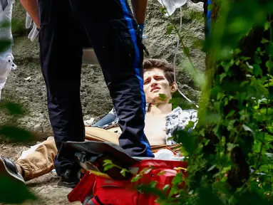 Seorang pemuda yang terluka parah menerima bantuan medis setelah mengalami luka akibat ledakan di Central Park, New York, Minggu (3/7). Kaki kirinya hampir putus akibat ledakan yang masih diselidiki sumber penyebabnya. (Kena Betancur/AFP)