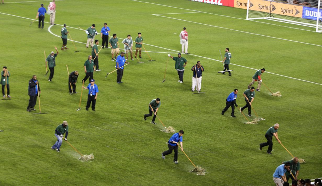 Petugas membersihkan genangan air akibat hujan badai yang menunda laga Cile melawan Kolombia dalam semifinal Copa America Centenario 2016 di Stadion Soldier Field, Chicago, AS, Kamis (23/6/2016) pagi WIB. (AFP/Tasos Katopodis)