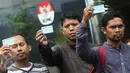 Sejumlah orang yang tergabung dalam Koalisi Masyarakat Sipil menunjukan KTP Elektronik saat melakukan aksi di depan Gedung KPK, Jakarta, Minggu (12/3). (Liputan6.com/Immanuel Antonius)