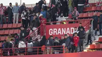 Suporter meninggalkan stadion Los Carmenes setelah laga antara Granada dan Athletic Bilbao pada jornada 16 La Liga Spanyol, Minggu (10/12/2023), ditangguhkan lantaran ada masalah di tribune, yaitu meninggalnya seorang penggemar. (JORGE GUERRERO / AFP)