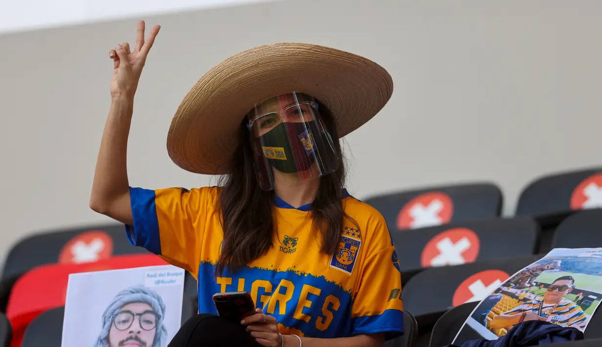 Fans cantik dari klub sepak bola asal Meksiko, Tigres mengacungkan lambang damai dalam pertandingan Piala Dunia Antar Klub 2020. (Foto: AFP/Karim Jaafar)