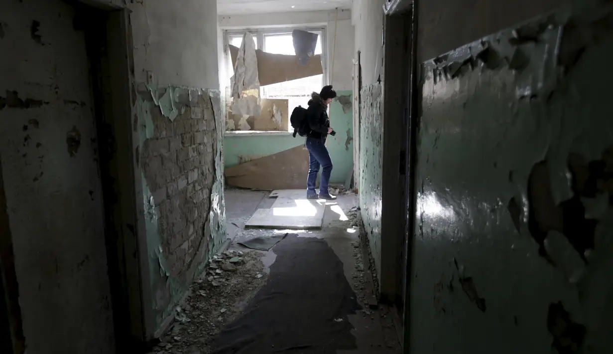 Seorang pengunjung melintasi suatu ruangan bekas kamp militer Uni Soviet di dekat Skrunda, Latvia (9/4). Lama tak dihuni tempat ini menjadi rusak dan terbengkalai. (REUTERS/Ints Kalnins)