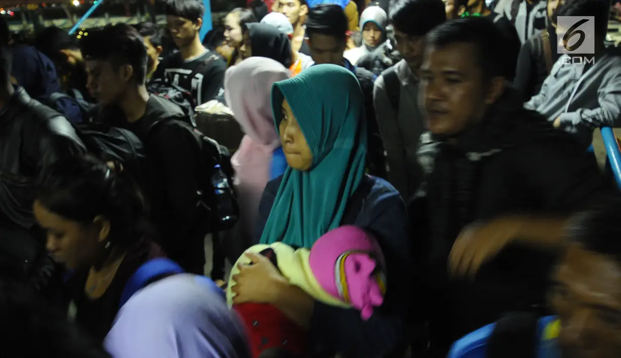 Pemudik menggendong balita ikut dalam antrian masuk ke dalam kapal penyeberangan di Dermaga I Pelabuhan Merak, Banten, Kamis (22/6). Dini hari, ribuan pemudik menyeberang dari Pelabuhan Merak menuju Bakauheni, Lampung. (Liputan6.com/Helmi Fithriansyah)
