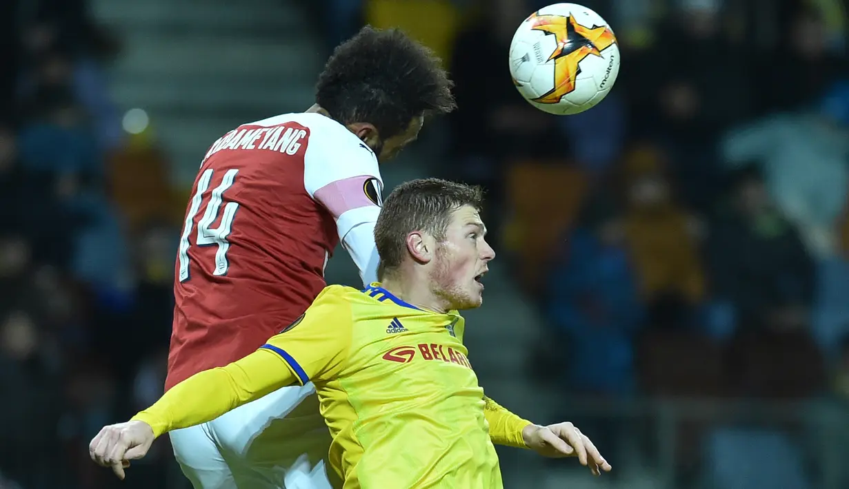 Penyerang Arsenal, Pierre-Emerick Aubameyang berebut bola dengan pemain BATE Borisov, Aleksandar Filipovic pada leg pertama 32 besar Liga Europa di Borisov Arena, Kamis (14/2). Arsenal kalah 0-1 saat bertandang ke markas Bate Borisov. (Sergei GAPON / AFP)